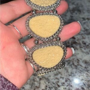 Yellow stone bracelet with silver metal surrounding it